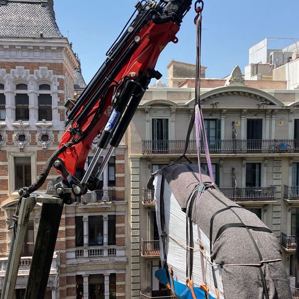 Piano en el aire siendo elevado por grua en edificio de mas de 15 metros