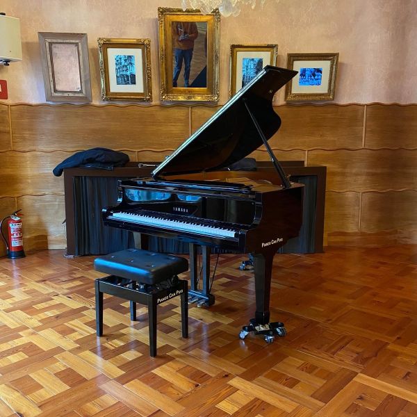 Piano de cola antiguo en sala de concierto despues de haber sido trasladado