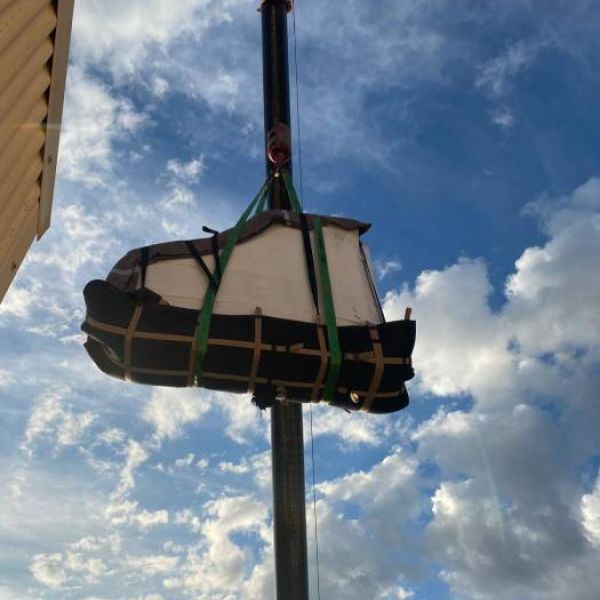 Piano elevado con grua siendo subido a un edificio
