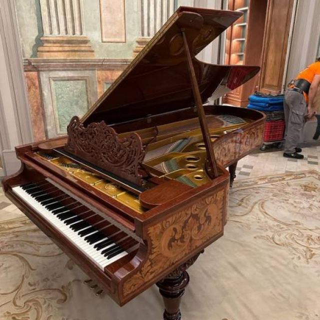 piano amuy antiguo de cola instalado en destino despues de una mudanza complicada.